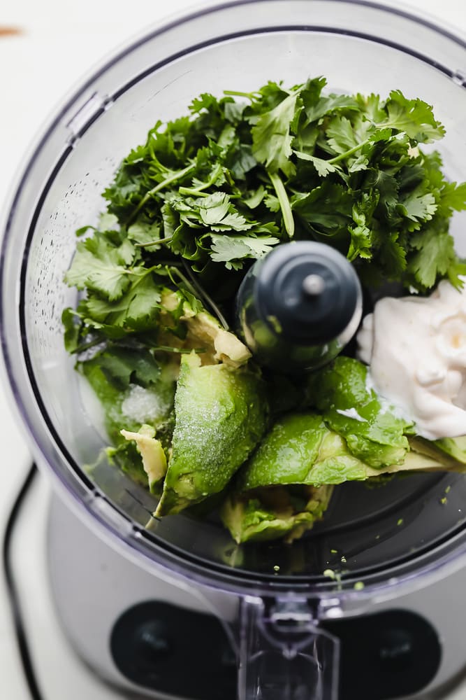 avocado sauce ingredients in a food processor.