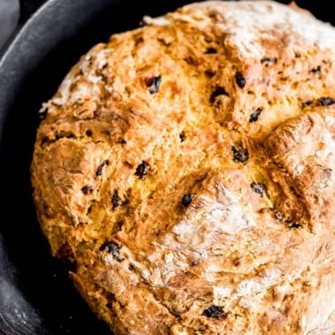 close up on vegan Irish soda bread in a black cast iron pan.