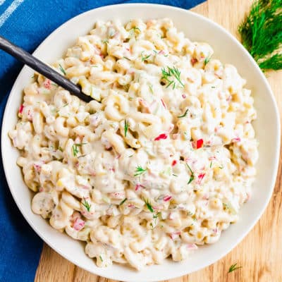 white bowl filled with macaroni salad and blue towel background