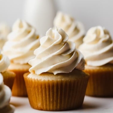square image of vanilla cupcakes with vegan frosting swirled on top