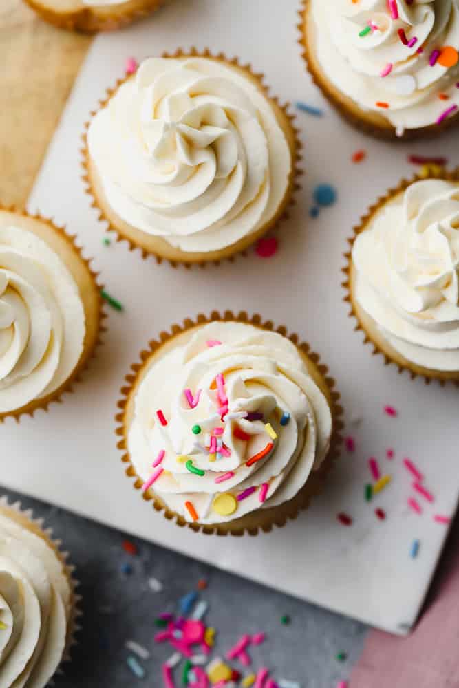 looking down on several vegan cupcakes, some with sprinkles and some without