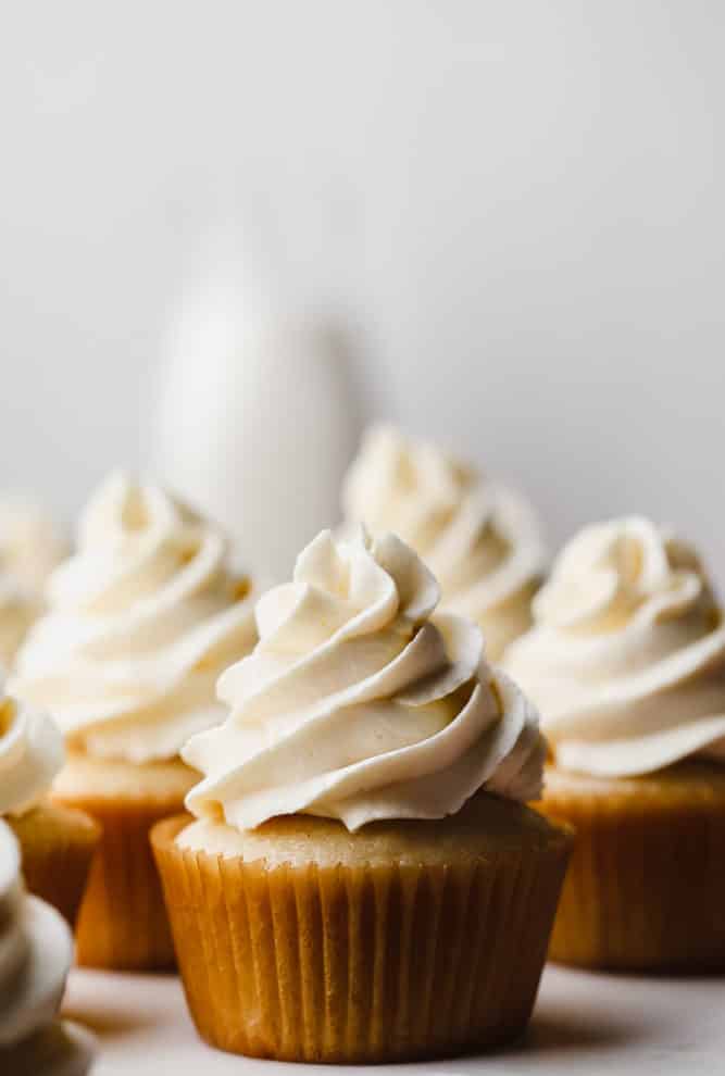 yellow cupcakes piped with swirly frosting