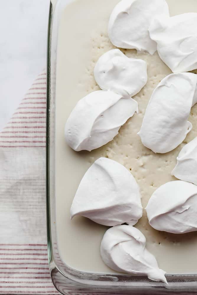 dollops of whipped cream on a milk soaked cake