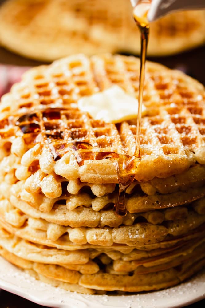 syrup drizzling on tall stack of waffles