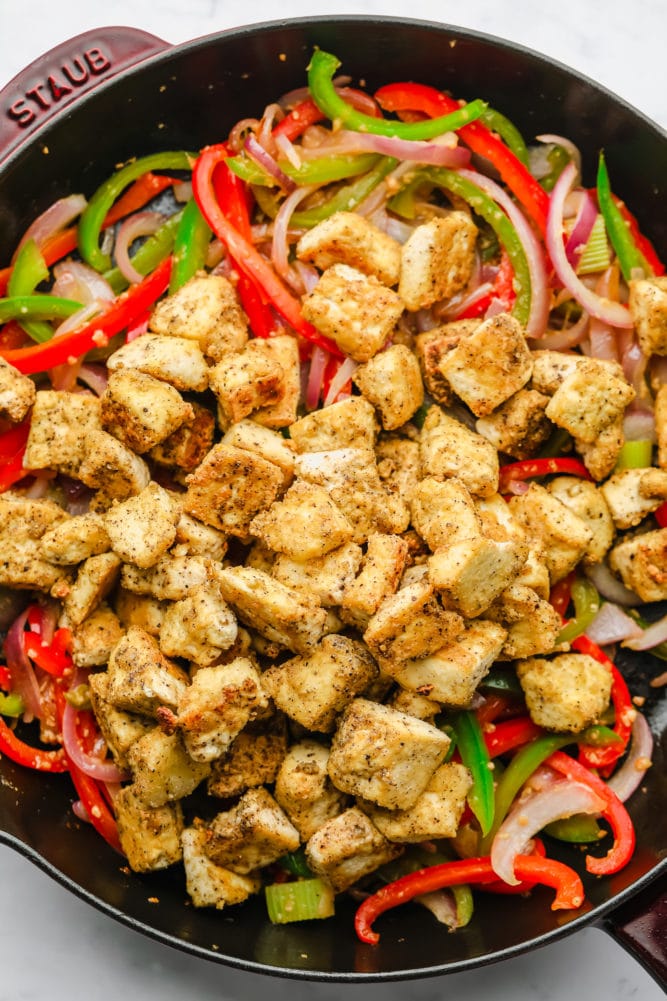 golden cooked tofu added to pan with peppers and onions
