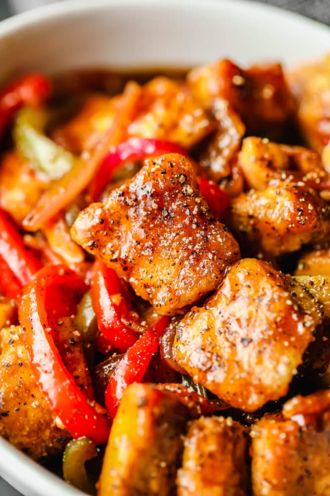 close up of cooked tofu and peppers with pepper all over