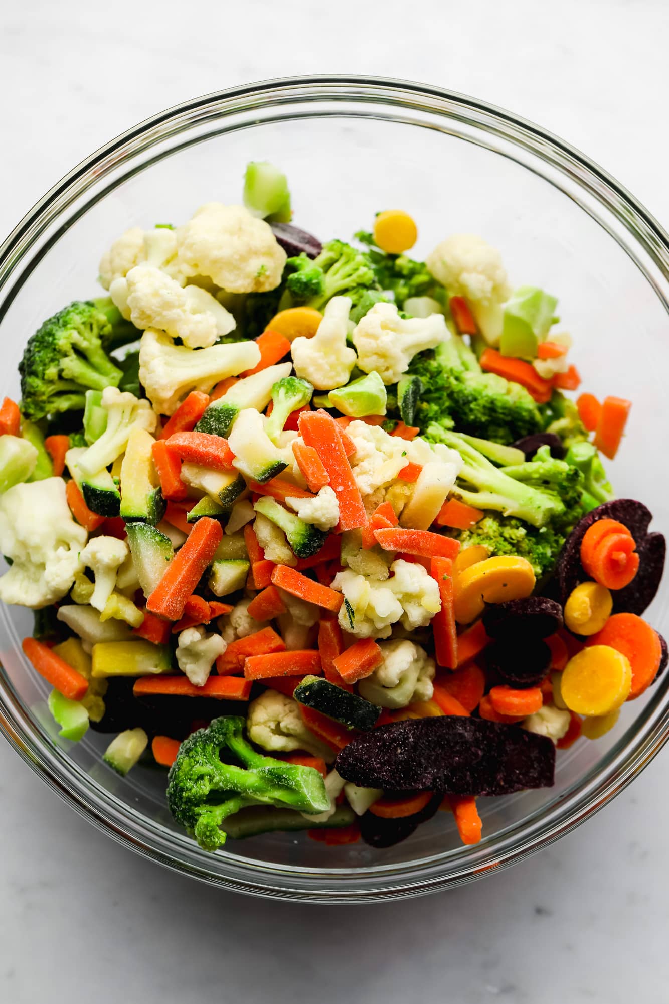 a medley of frozen vegetables in a glass bowl.