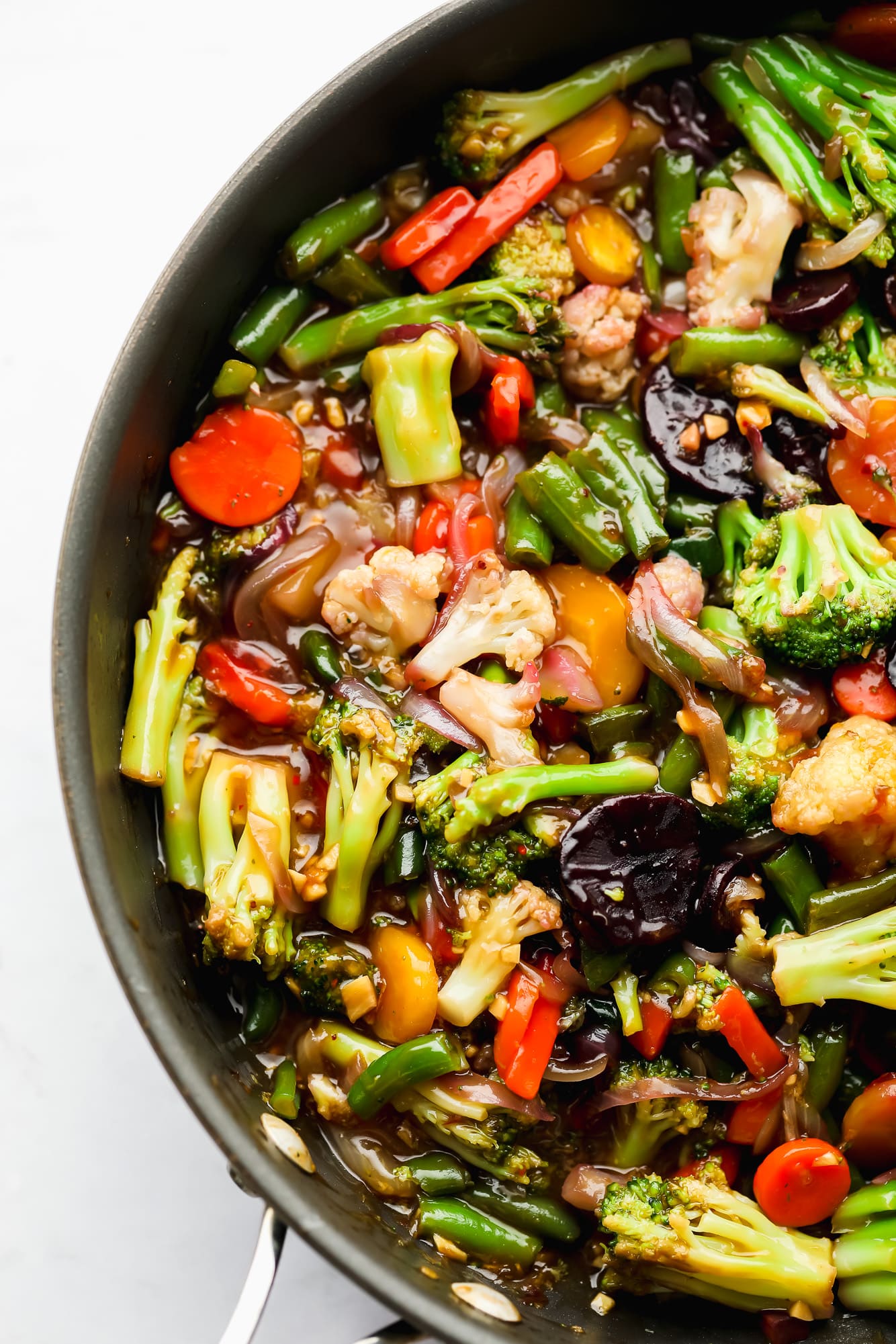 sauce-covered cooked vegetables in a large black skillet.