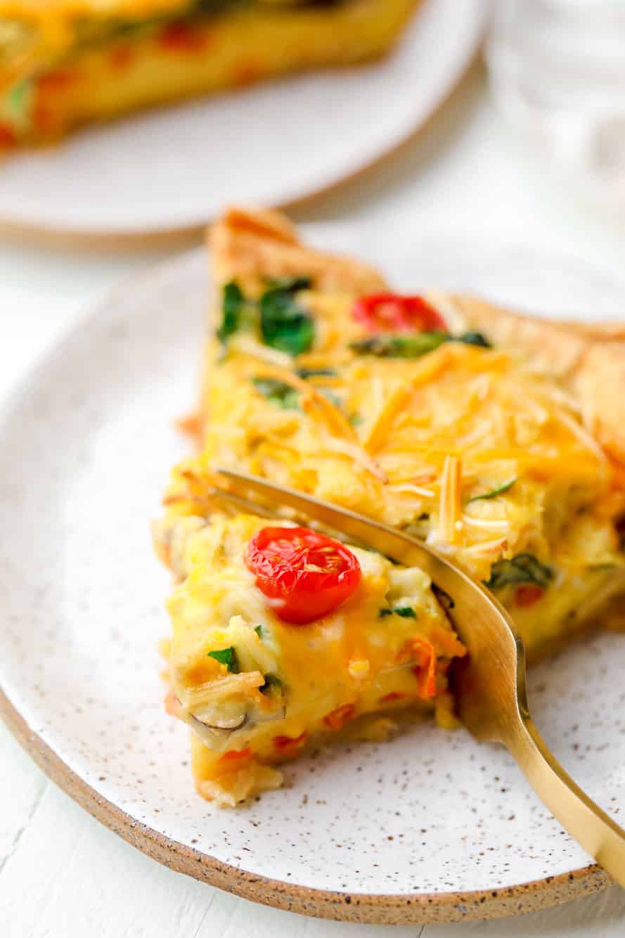 A fork taking a bite out of a slice of JUST Egg quiche.