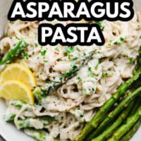 pinterest image of lemon asparagus pasta topped with cooked asparagus and lemon slices in a white bowl.