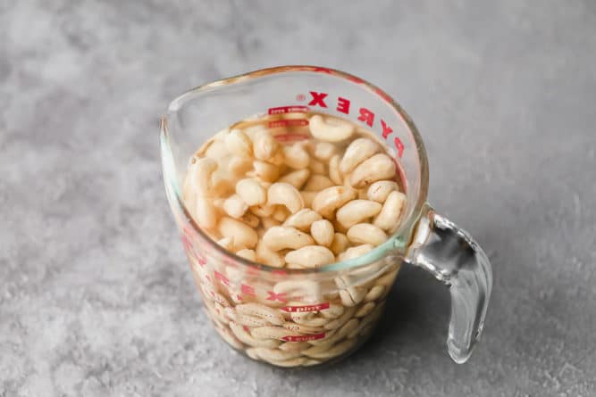 cashews soaking in a measuring cup