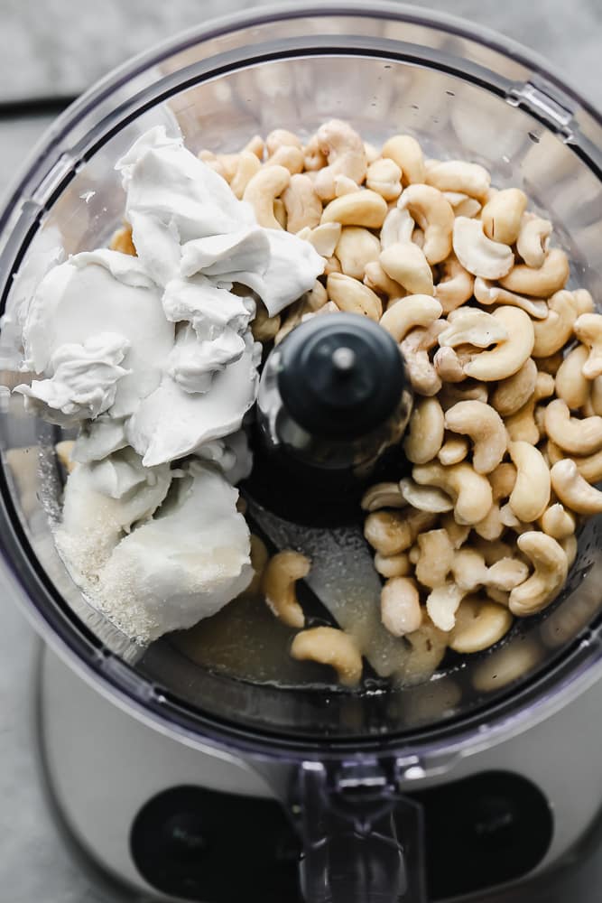 food processor with cashews, coconut cream, sugar before blending