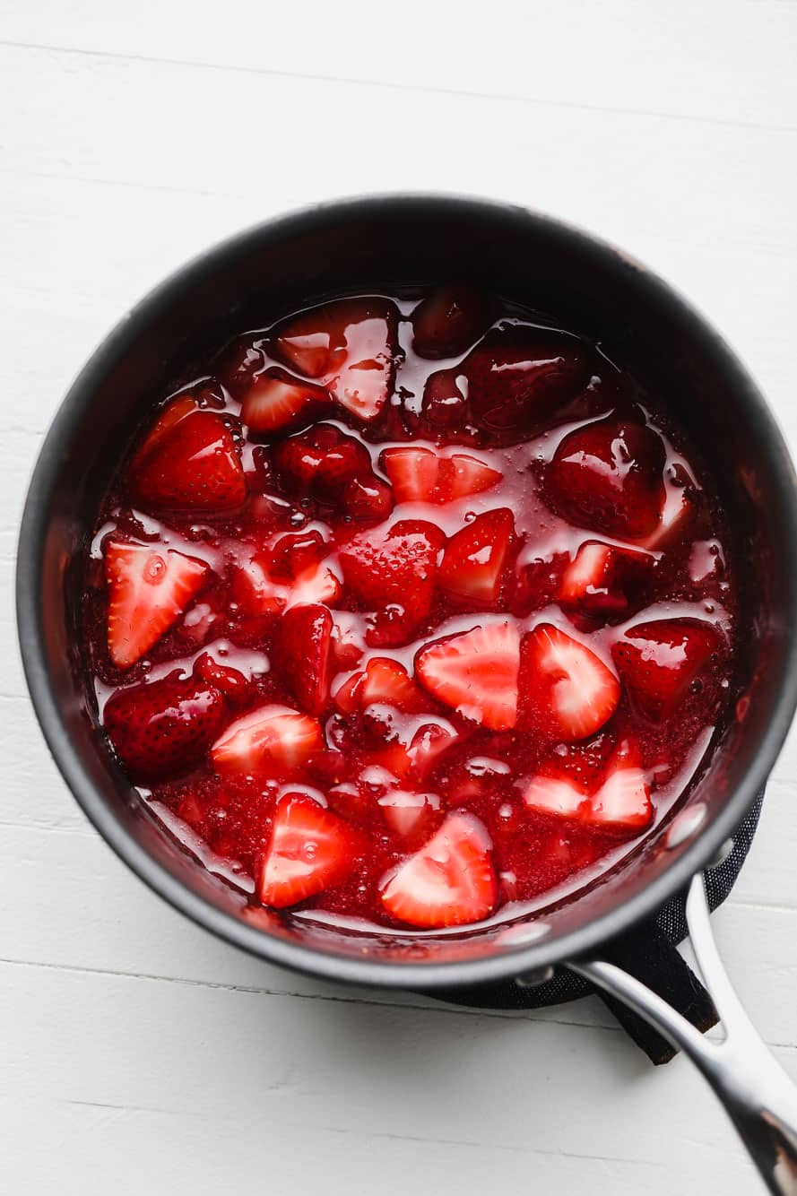 cooking strawberry sauce in a saucepan.
