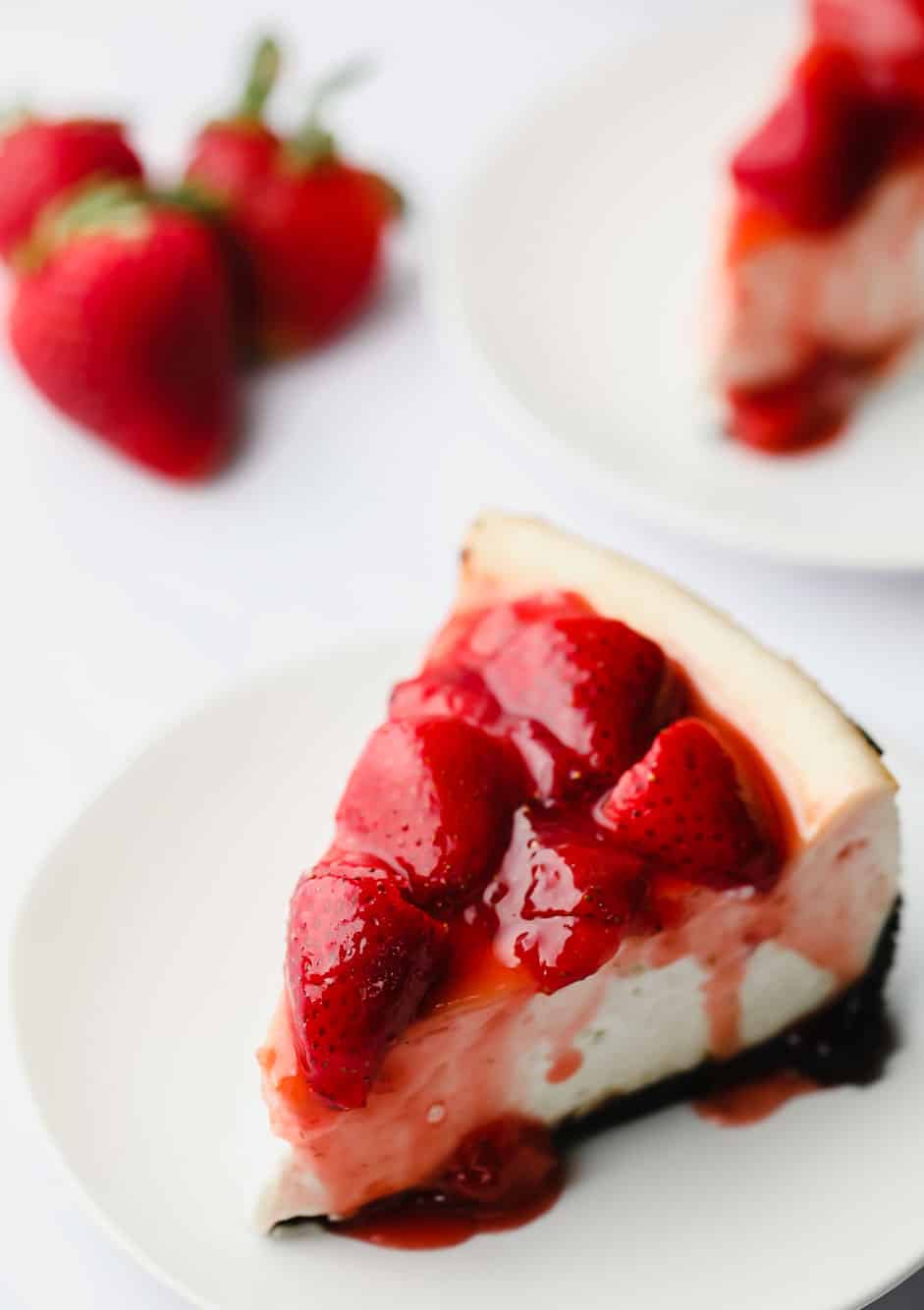 a slice of vegan strawberry cheesecake on a white plate.