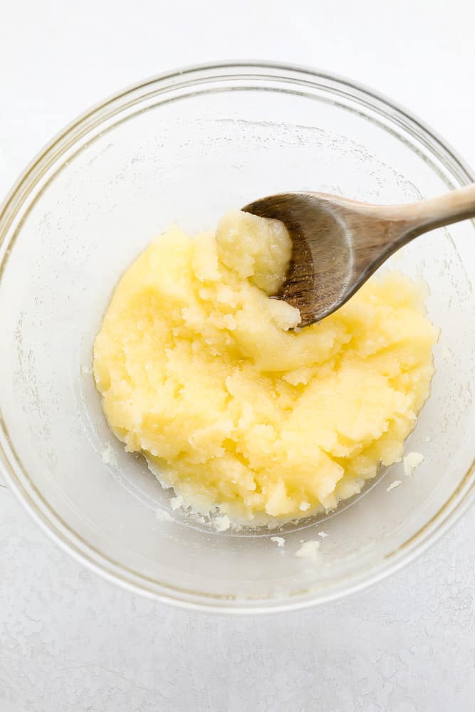 butter and sugar in a bowl with wooden spoon