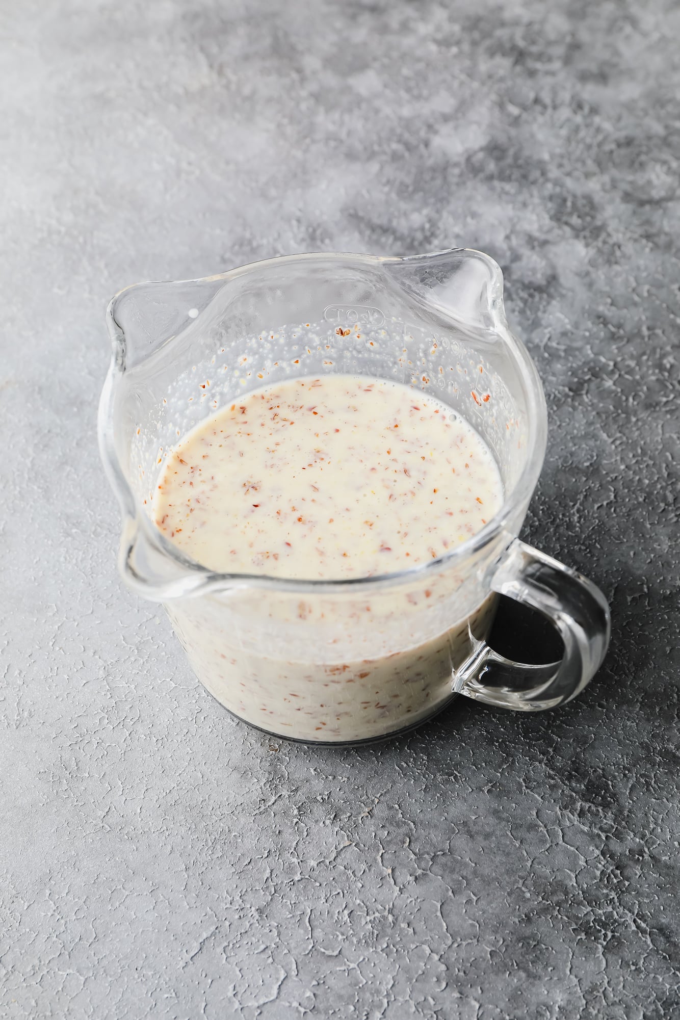 a vegan buttermilk and flaxseed mixture in a glass measuring cup.