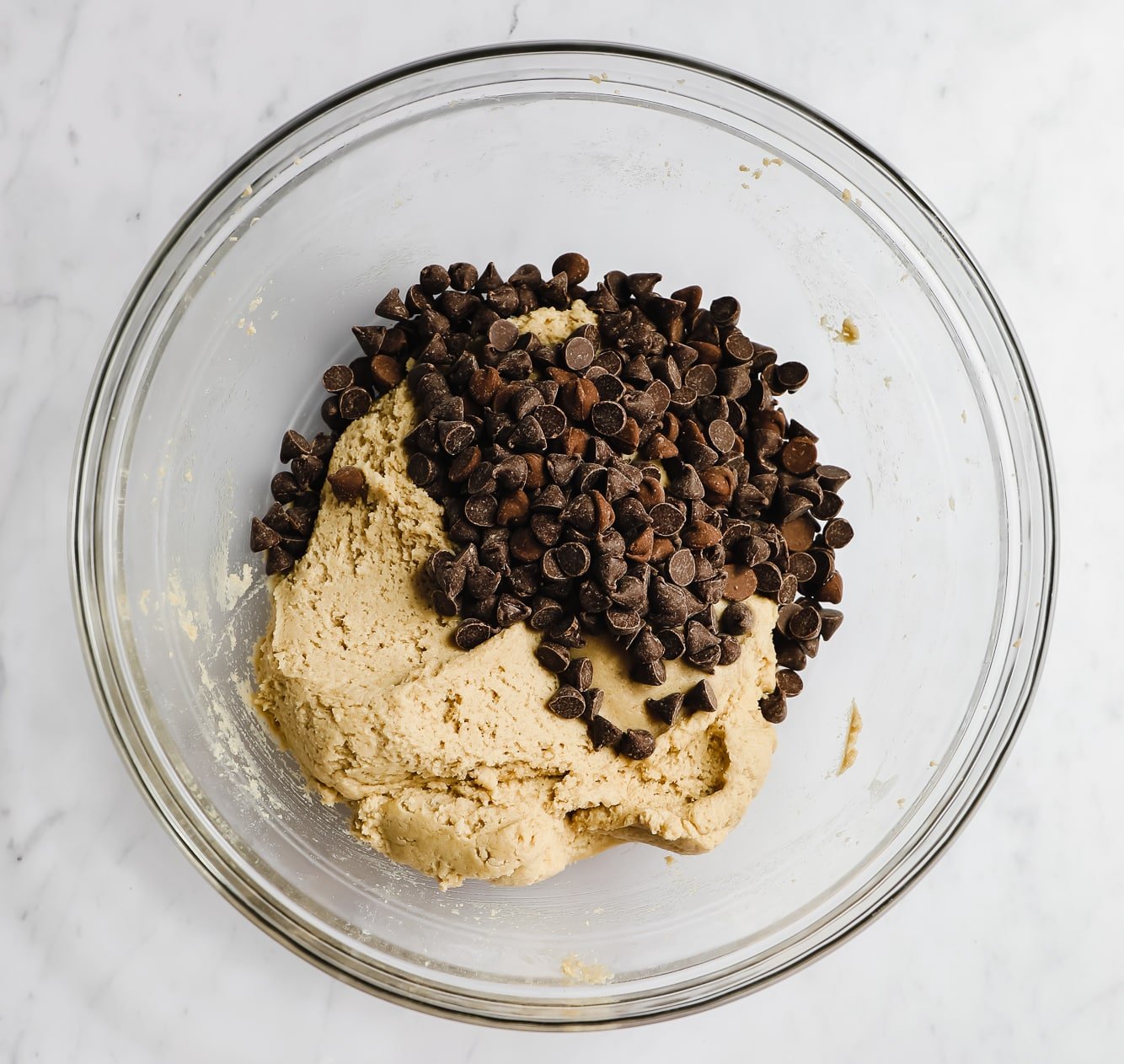 cookie dough in a glass bowl with chocolate chips