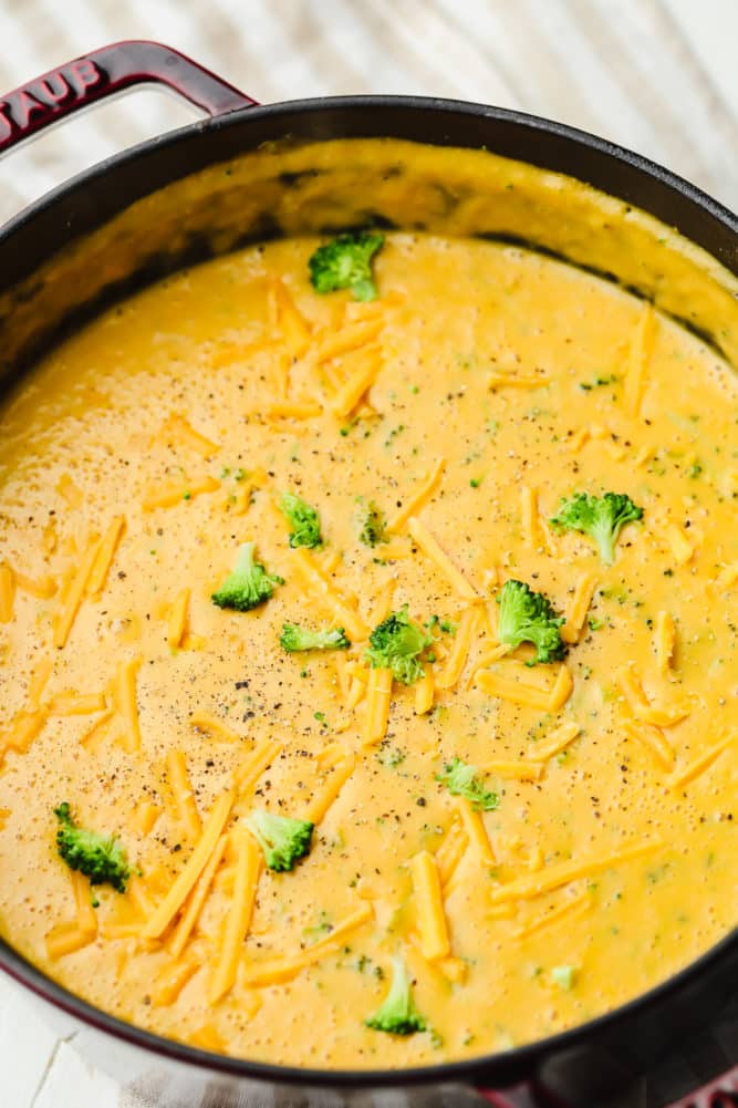 a large black pot filled with vegan broccoli cheddar soup.