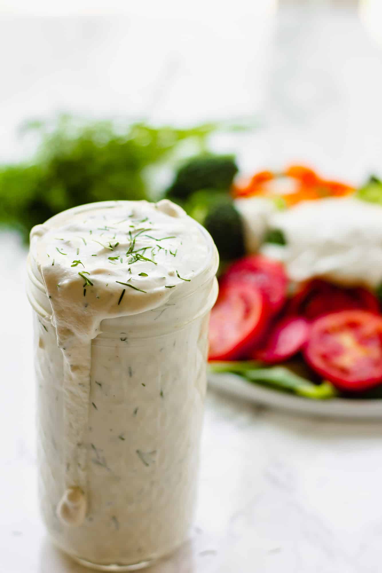 close up on a glass jar filled with vegan ranch dressing.