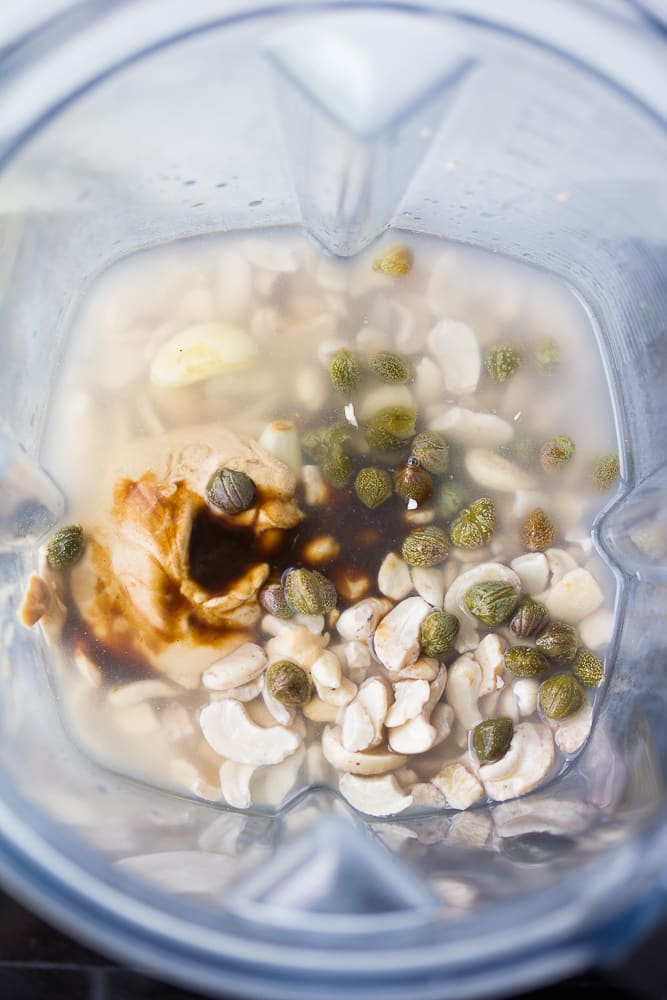 the ingredients for vegan caesar dressing in a blender.