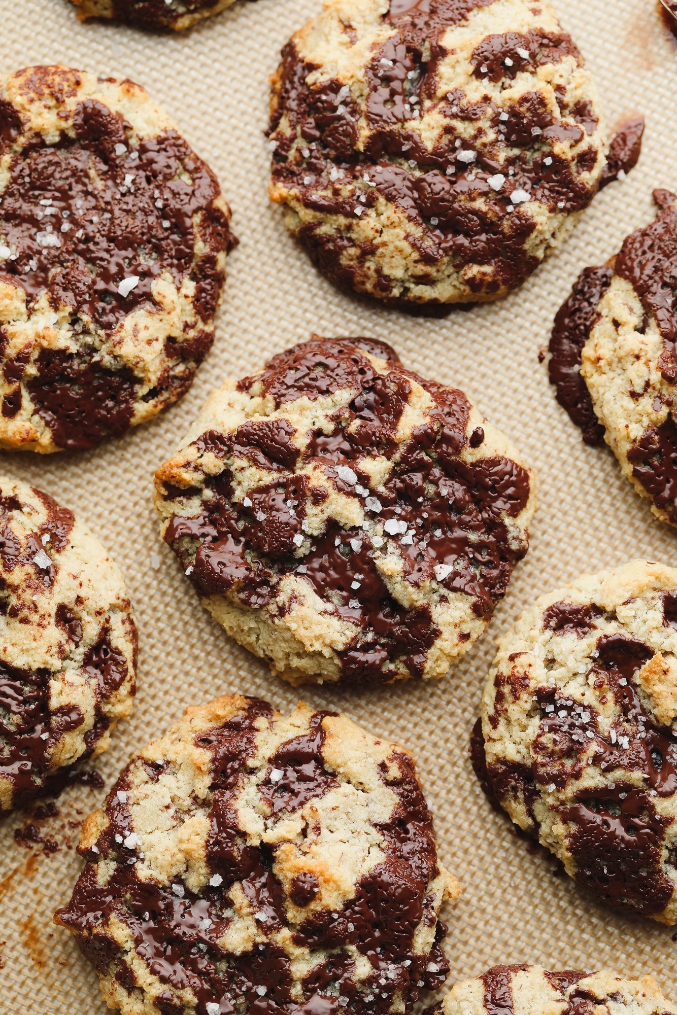 close up on baked almond flour cookies on a lined baking sheet.