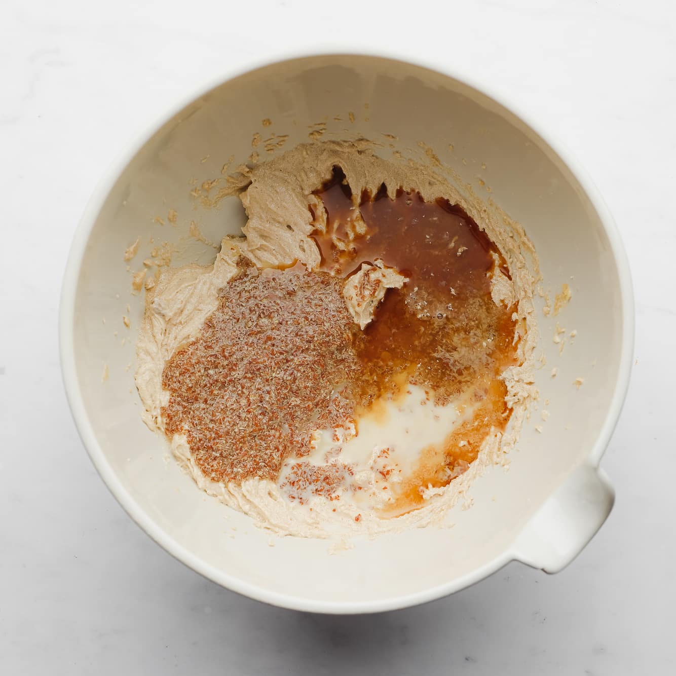 wet cookie dough ingredients mixed together in a large white bowl.