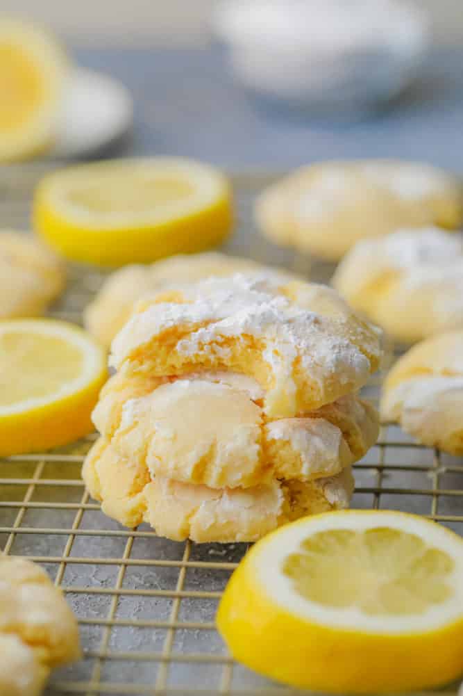 stack of 3 lemon cookies with a bite taken out of the top one