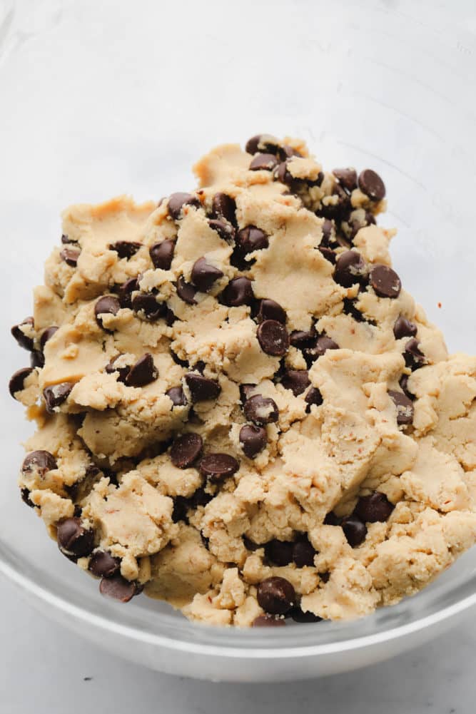 chocolate chip cookie dough in a glass bowl with white background