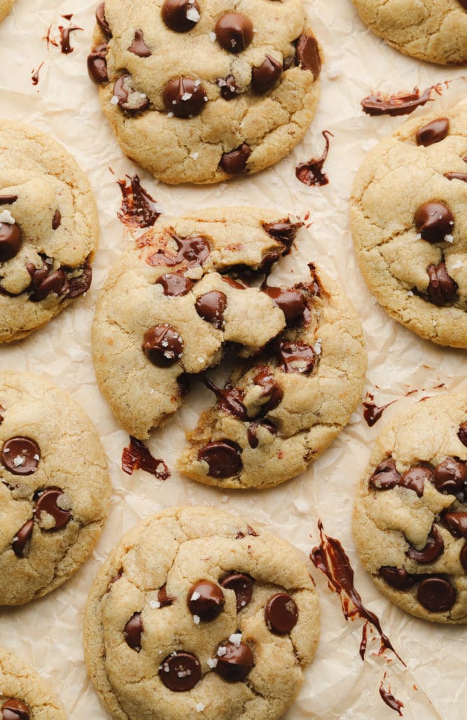 broken vegan chocolate chip cookie on parchment paper with sea salt