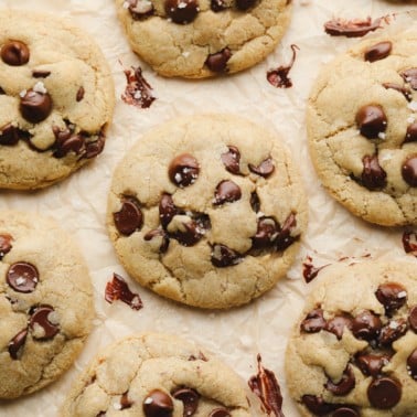 crinkled parchment paper with chocolate chip cookies flat on it