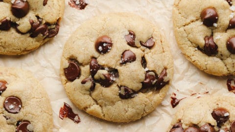 crinkled parchment paper with chocolate chip cookies flat on it