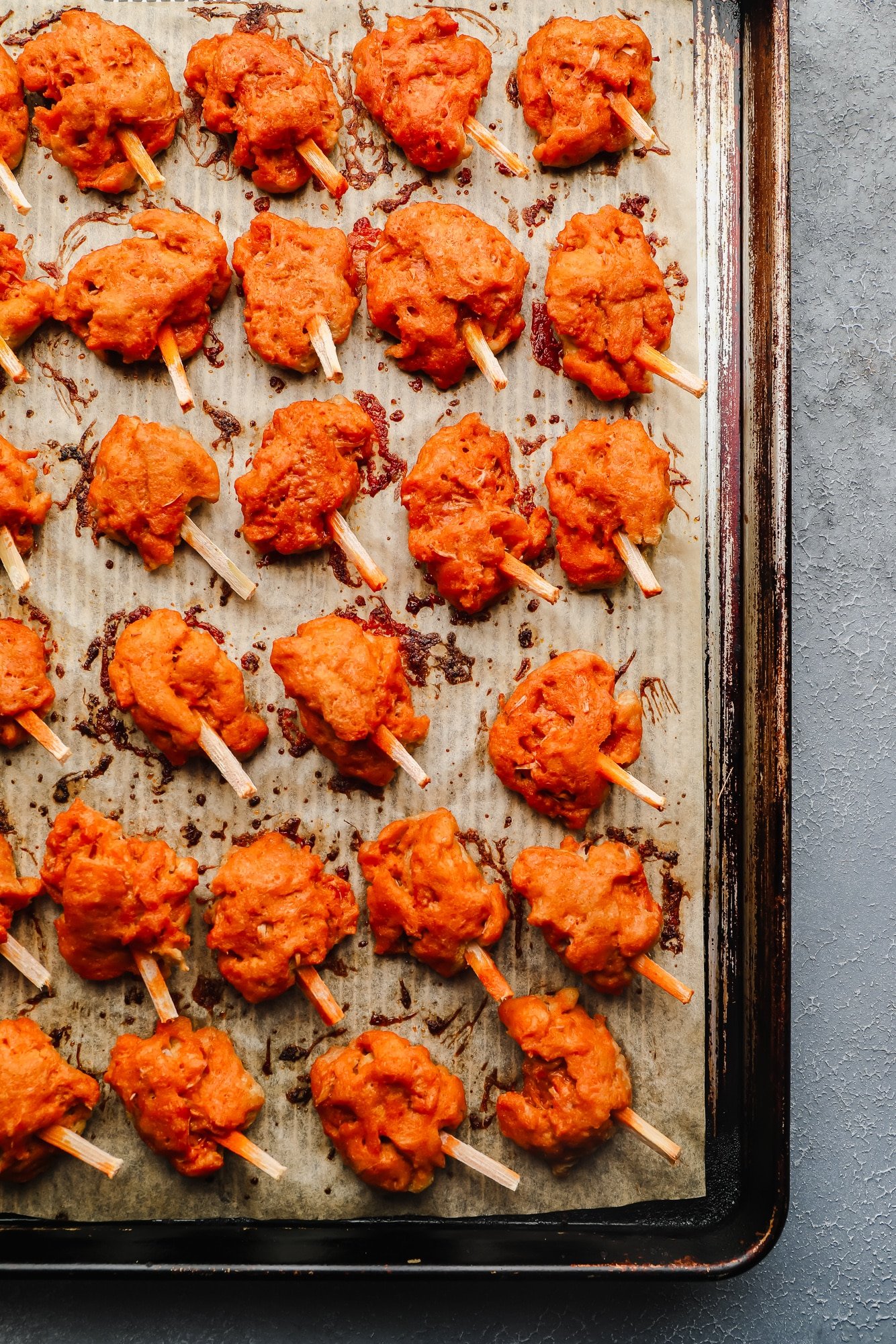 baked wings on a parchment lined baking sheet.