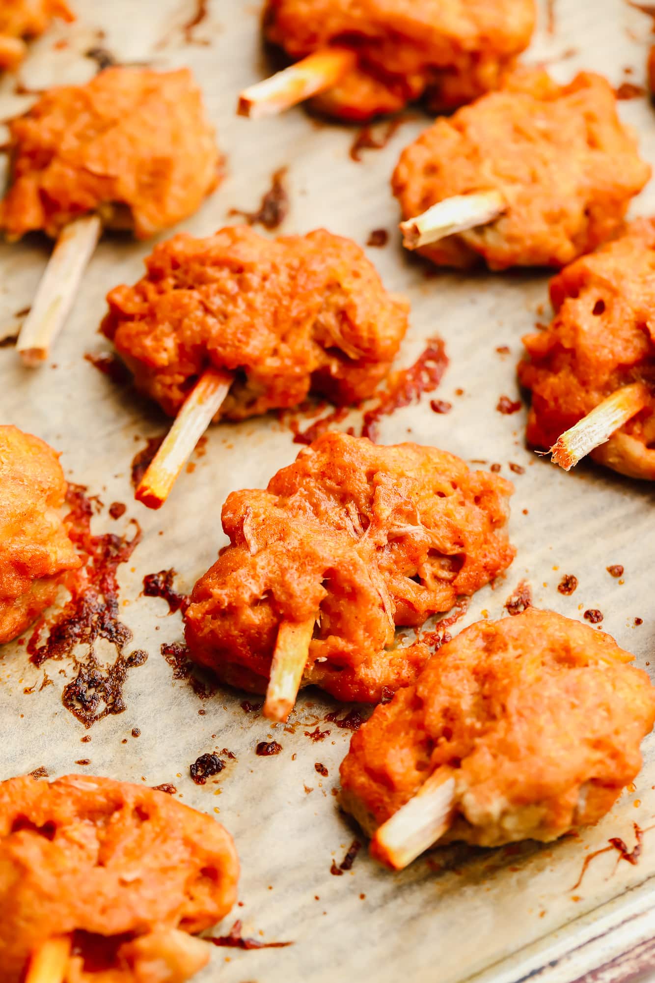 close up on baked orange "meat" on a parchment lined baking sheet.