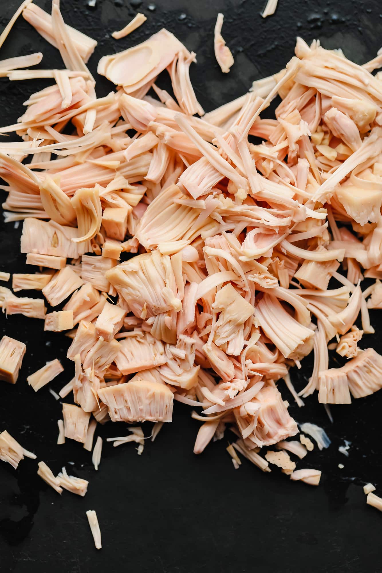 shredded jackfruit on a black board.