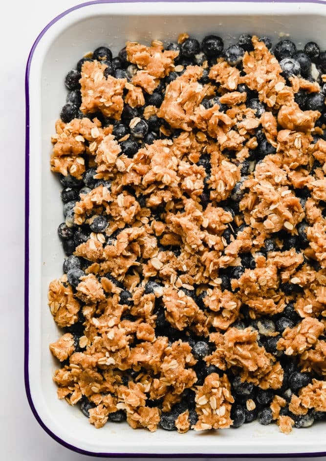 uncooked oat topping on blueberries in dish