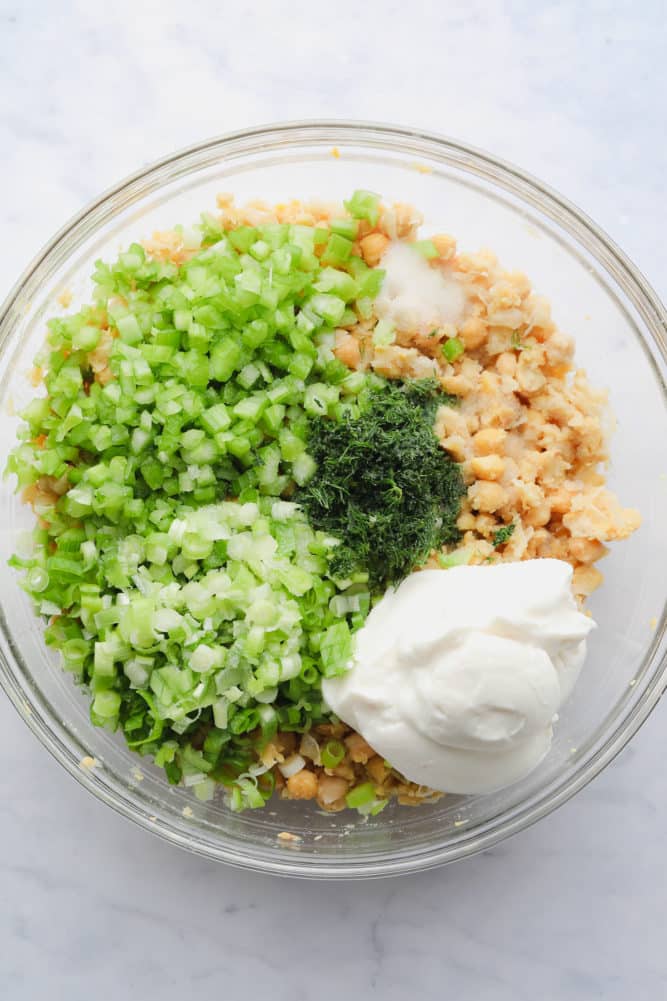 bowl with mashed chickpeas, green ingredients and mayo