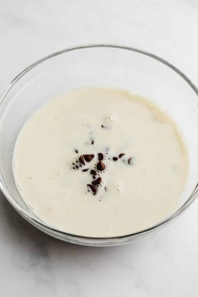 chocolate chips and milk in a glass bowl