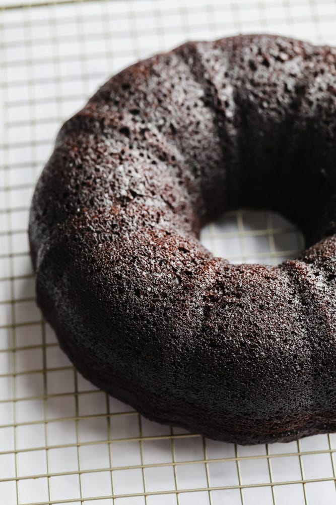 unfrosted vegan bundt cake, chocolate on cooling rack