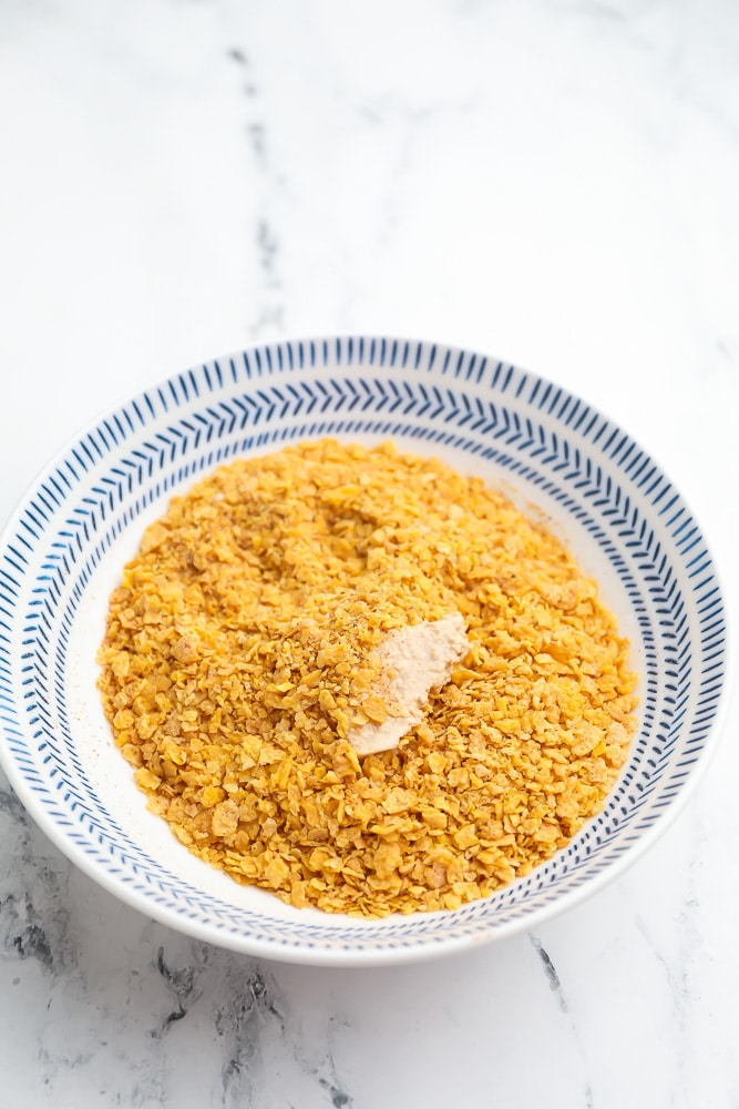 bowl with processed cornflakes and tofu being rolled in it