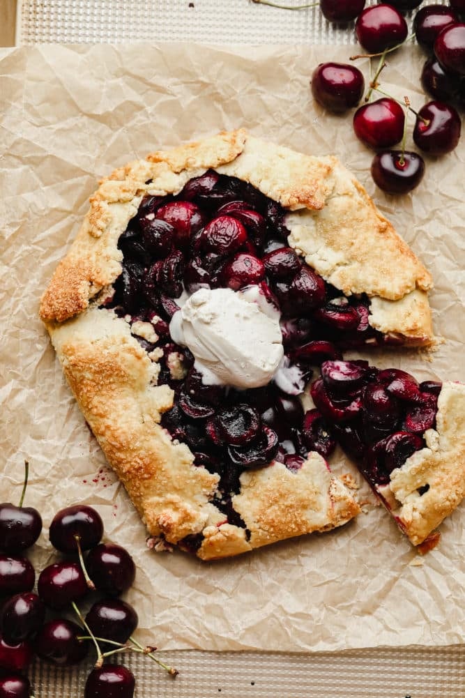 cherry galette cut into on parchment paper