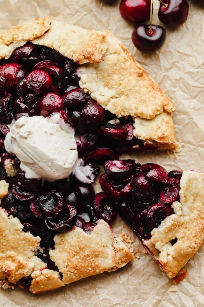 close up of galette with cherries and vanilla ice cream