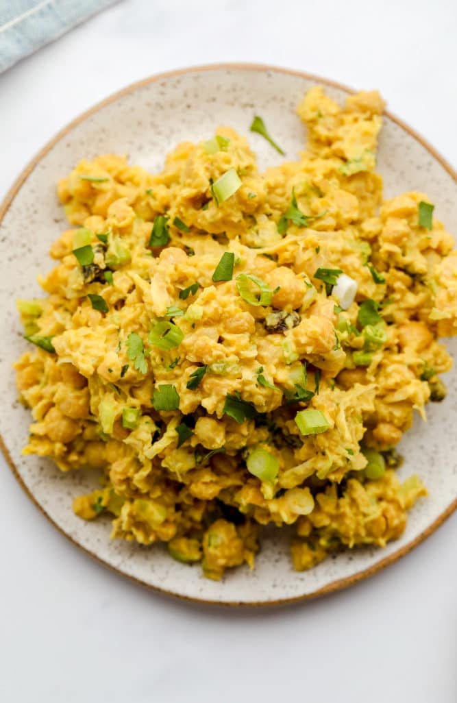 curry chickpea salad on a plate with green onions sprinkled