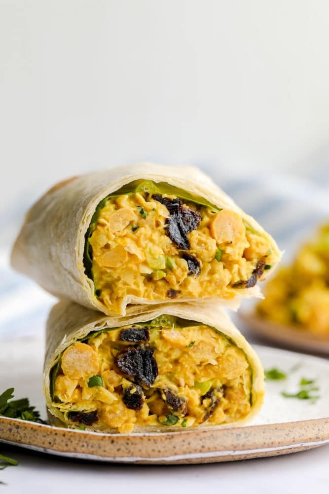 wrap cut in half with curry chickpea salad on a plate