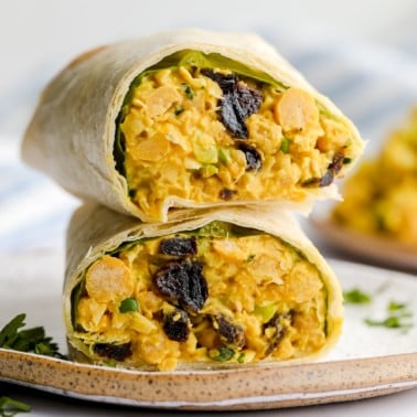 square image of a wrap with bean yellow mixture and raisins on a plate