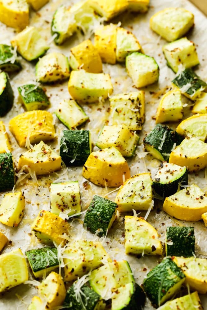 yellow squash and zucchini roasted with cheese on tan parchment paper