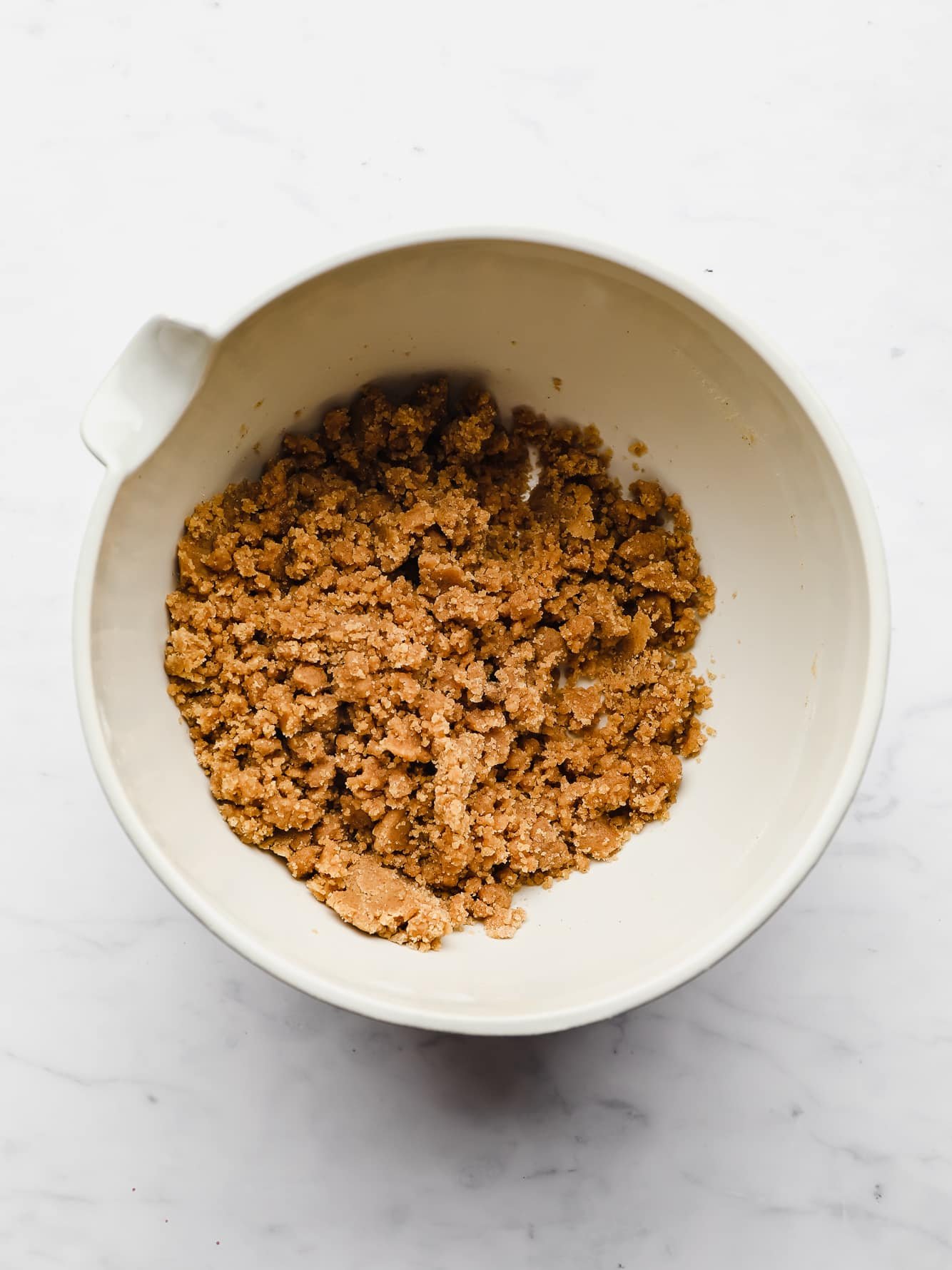 making a brown sugar streusel in a white bowl.