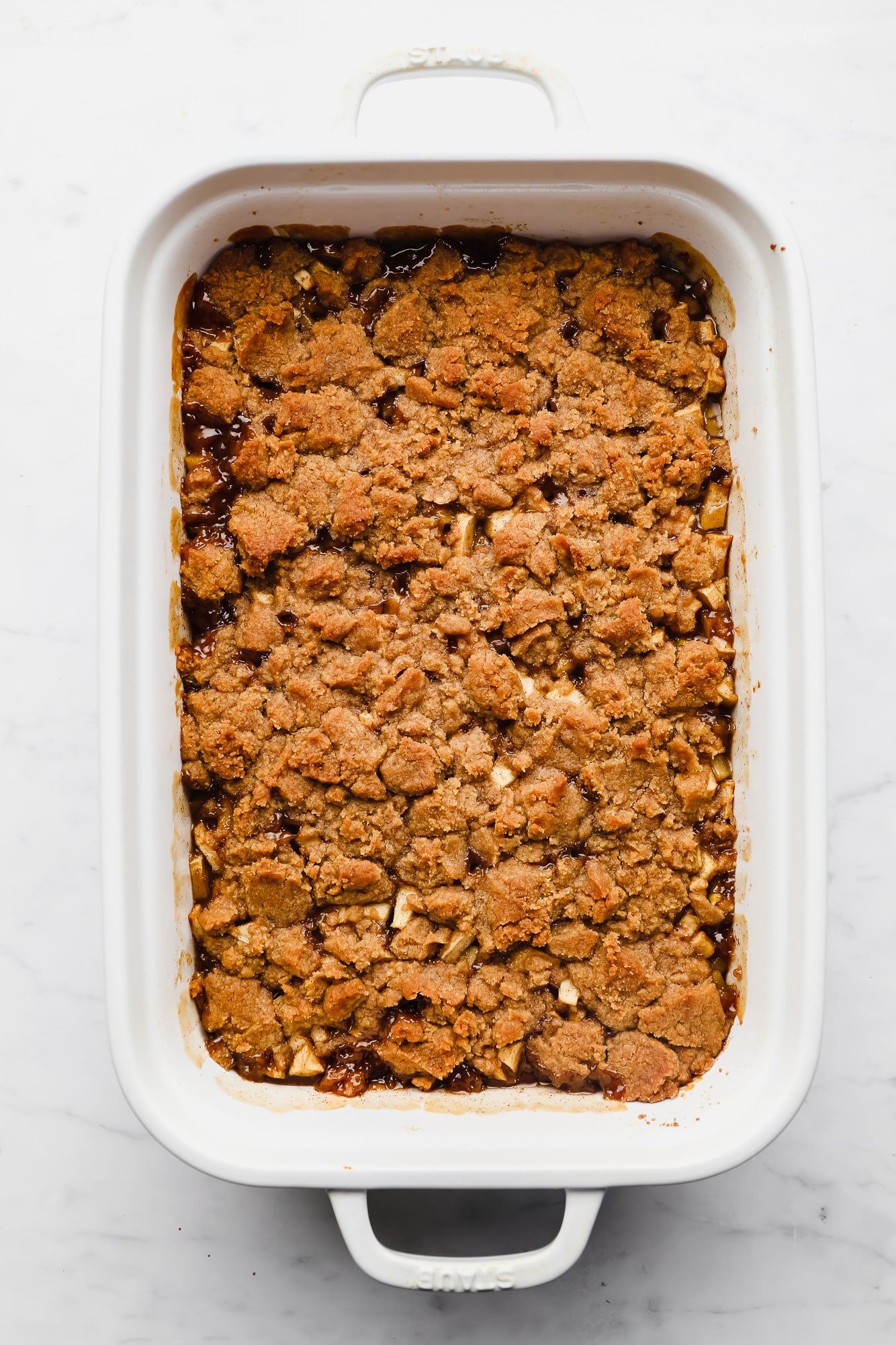 a baked apple crumble in a large white casserole dish.