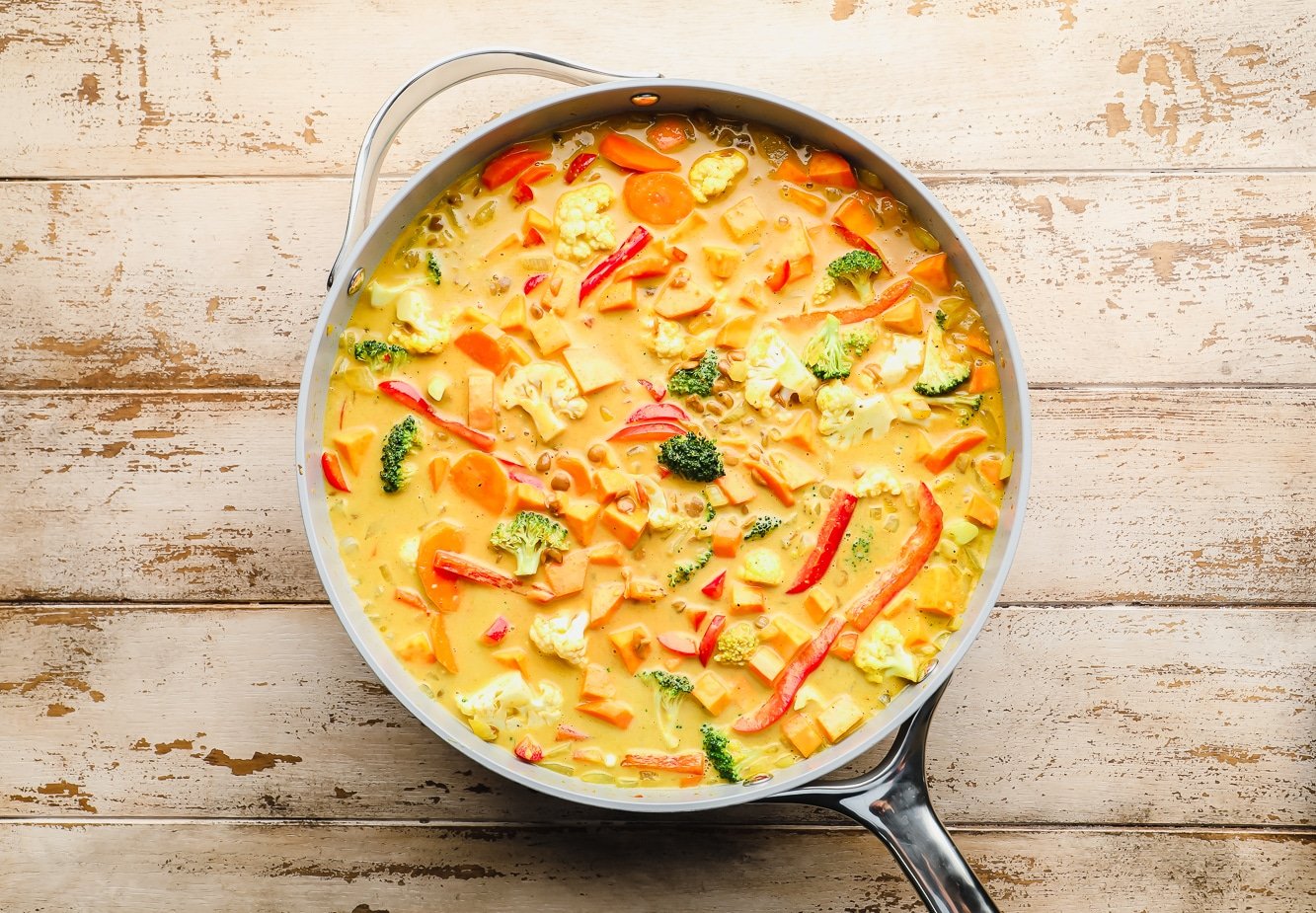a large grey pot filled with cooked yellow vegan curry.