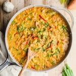 vegan curry in a large grey pot with a wooden spoon sticking out.