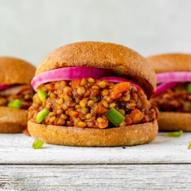square image of a bun with lentils, green peppers and red onion, white background